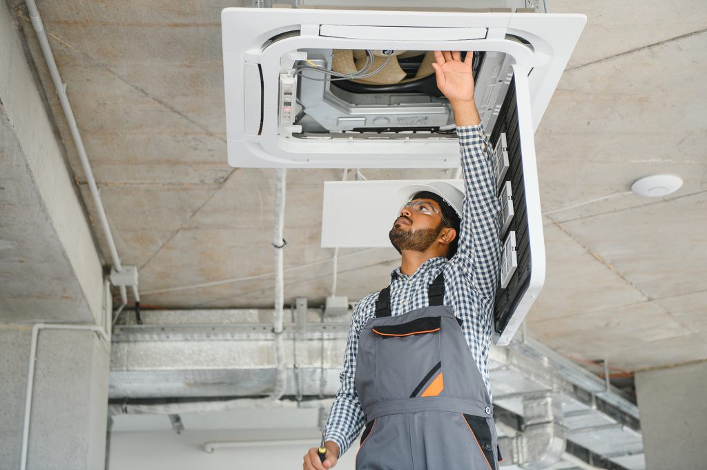 An HVAC professional works through field service management challenges while on the job