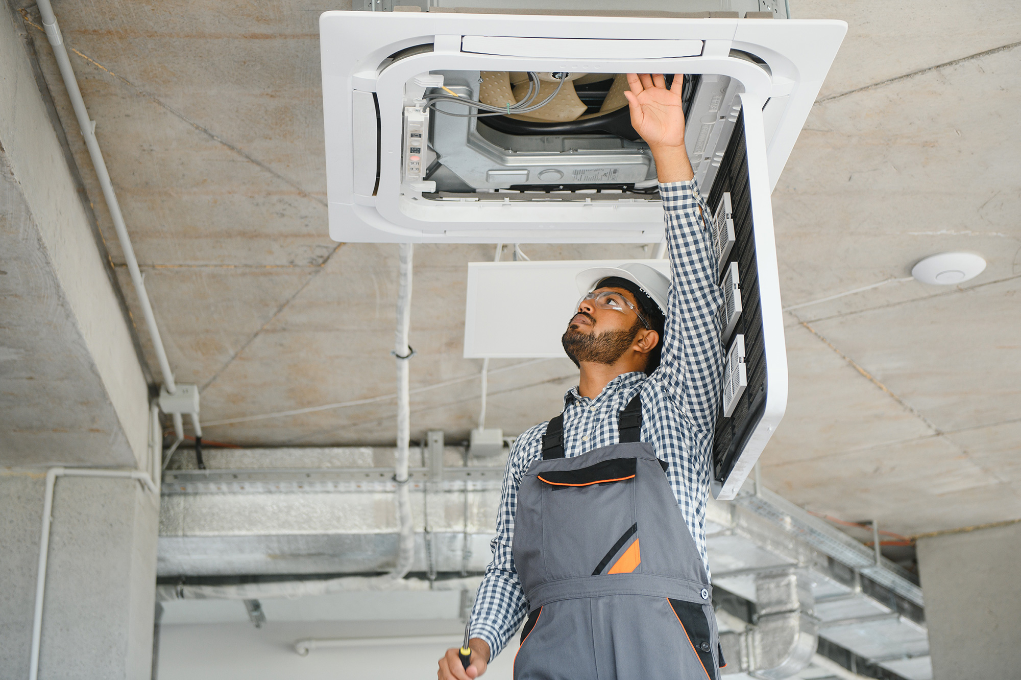 An HVAC professional works through field service management challenges while on the job