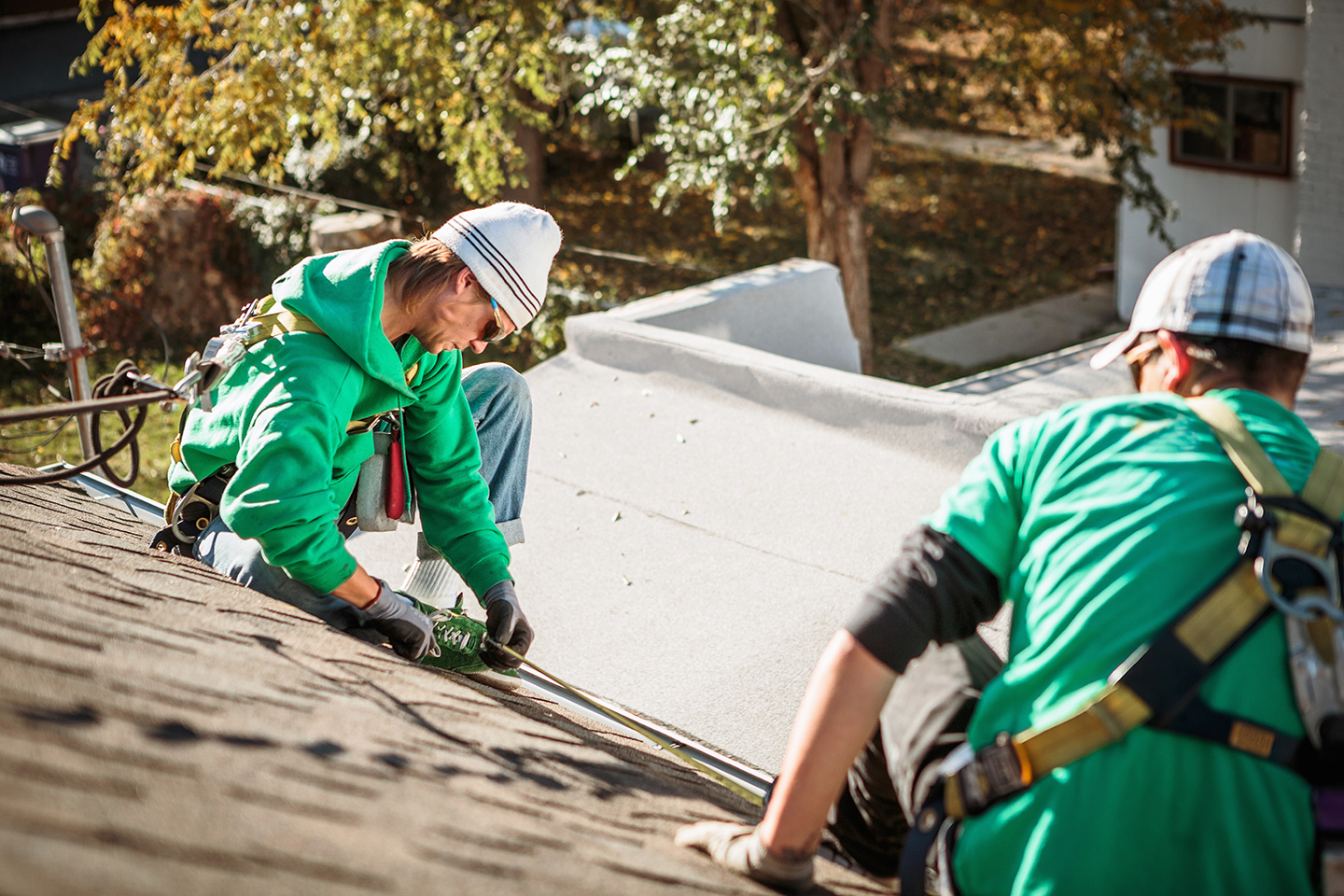 Roofers from a field service management business work on a job site